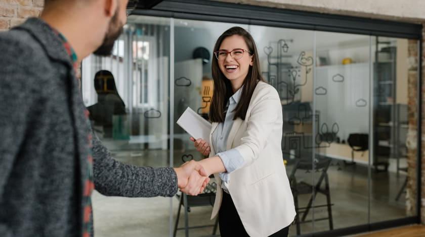 Career program student in suit shaking hands with a professional